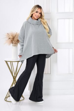 Modelo usando la Ruana Monserrate de color gris medio, con cuello tortuga alto y diseño asimétrico. Prenda tejida artesanal de la marca colombiana Tejidos WMM, ideal para clima frío y estilo clásico elegante.